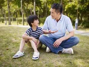 asian father and son having a conversation